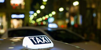 sinal-de-taxi-iluminado-na-cidade-a-noite_106485-3367